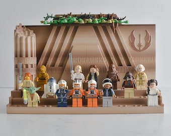 May include: A tan plastic display stand featuring a Jedi Order symbol and architectural details, holding a collection of fourteen Star Wars LEGO minifigures including Yoda, Luke Skywalker, Chewbacca, and Princess Leia, arranged on tiered levels.