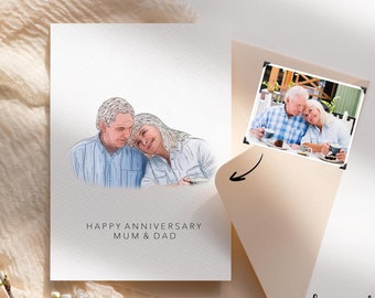 May include: An anniversary card with a watercolor-style portrait of an elderly couple. The card reads "HAPPY ANNIVERSARY MUM & DAD." A small photo of the couple is included. The card is on a beige surface with a floral branch.
