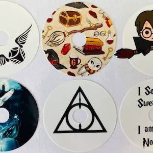 Puede incluir: Seis pegatinas redondas con varios diseños de temática de Harry Potter. Los diseños incluyen el símbolo de las Reliquias de la Muerte, una escena del castillo de Hogwarts, una escoba voladora, un mago, una snitch y una cita del libro.