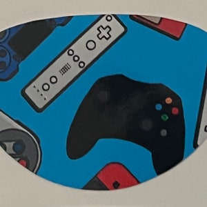 May include: A blue background with a pattern of various video game controllers, including a black Xbox controller, a white Wii remote, and a blue PlayStation controller.