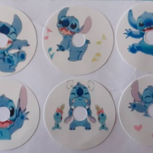 Op de afbeelding: Zes ronde stickers met een blauw cartoonfiguur met grote oren en een ondeugende uitdrukking. Het personage is Stitch uit de Disney-film Lilo & Stitch. Elke sticker heeft een ander ontwerp, waaronder Stitch die muziek maakt, Stitch met harten en Stitch met andere personages.
