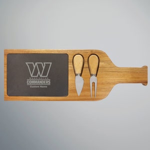 Puede incluir: Tabla de queso de madera con forma de botella de vino con una zona de servicio de pizarra. La pizarra tiene el logotipo de los Washington Commanders y el texto "Washington Commanders Custom Name". La tabla incluye dos cuchillos para queso.