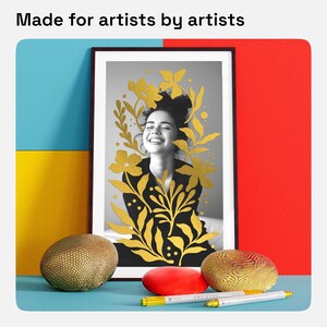 May include: A framed black and white photo of a woman with gold leaf floral designs. The photo is displayed on a table with two decorative gold and brown stones and a red stone.