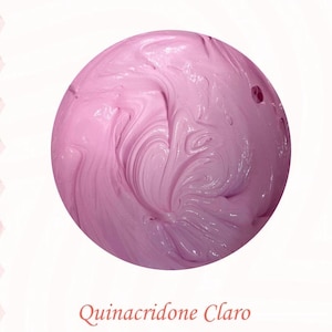 May include: A close-up of a pink, swirling substance in a circular shape. The texture appears smooth and creamy, with visible ridges and swirls. The text "Quinacridone Claro" is written in a cursive font below the circle.