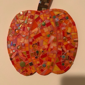 Vibrant orange mosaic pumpkin with hints of green.