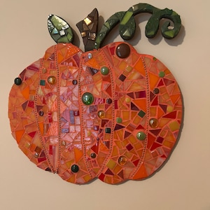 Vibrant orange mosaic pumpkin with hints of green.
