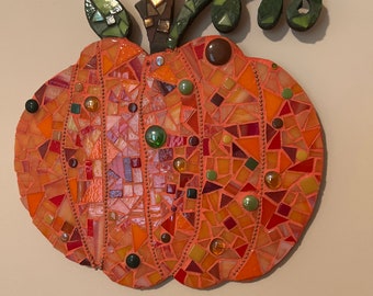 Vibrant orange mosaic pumpkin with hints of green.