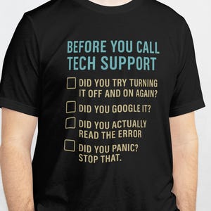 May include: Black t-shirt with the text "BEFORE YOU CALL TECH SUPPORT" in teal and white. Below the text are four questions with checkboxes: "DID YOU TRY TURNING IT OFF AND ON AGAIN?" "DID YOU GOOGLE IT?" "DID YOU ACTUALLY READ THE ERROR" "DID YOU PANIC? STOP THAT."
