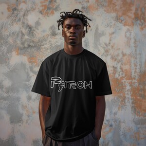 Puede incluir: Una camiseta negra con un dise&ntilde;o gr&aacute;fico blanco que dice "PYRON" en una fuente estilizada.