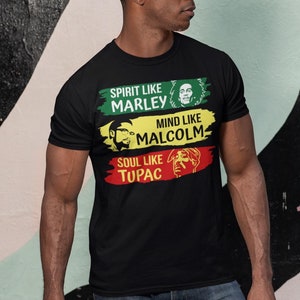 May include: Black t-shirt with a graphic print of three famous figures. The text reads "Spirit like Marley, Mind like Malcolm, Soul like Tupac".