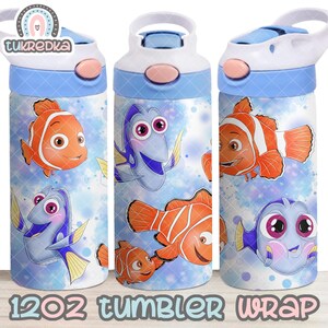 Puede incluir: Botella de agua azul y blanca con personajes de peces de dibujos animados. La botella tiene un asa blanca y una tapa azul con un botón rosa. El diseño incluye peces payaso naranjas y blancos y peces cirujanos azules. El texto "1202 TUMBLER WRAP" está en la parte inferior.