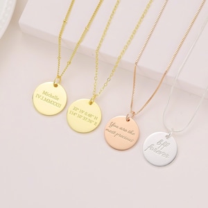 Puede incluir: Cuatro collares de oro, oro rosa y plata con colgantes redondos. Los colgantes están grabados con el texto "Michelle IV.I.MMXXII", "22° 19° 0.48" N 114° 10° 37.76" E", "You are the most precious" y "Bff forever".