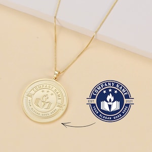 Puede incluir: Collar de oro con un colgante redondo que presenta un logotipo de empresa azul y blanco. El logotipo incluye un libro con una antorcha, tres estrellas y el texto "Company Name", "Est. 2021" y "Your Slogan Goes Here".