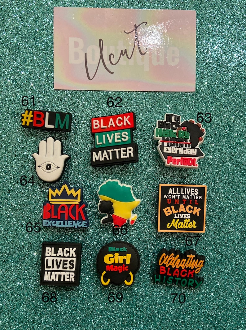 May include: A collection of ten colorful shoe charms featuring various designs and text including #BLM, Black Lives Matter, Black Excellence, Black Girl Magic, and Celebrating Black History, arranged in a grid with numbered labels from 61 to 70.