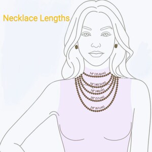 May include: Illustration showing necklace lengths. The image displays a woman with various necklace lengths around her neck, including 14" (35.6cm), 16" (40.5cm), 18" (46cm), 20" (51cm), and 24" (61cm). The text "Necklace Lengths" is at the top.