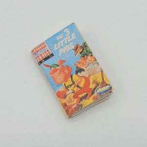 May include: A vintage paperback book titled "The 3 Little Pigs" from the "Classics Junior" series. The cover features an illustration of the three pigs and the wolf.