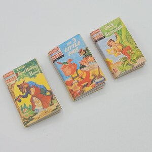 May include: Three miniature hardcover books with colorful illustrations. The titles are "Little Red Riding Hood", "The 3 Little Pigs", and "Jack and the Beanstalk".