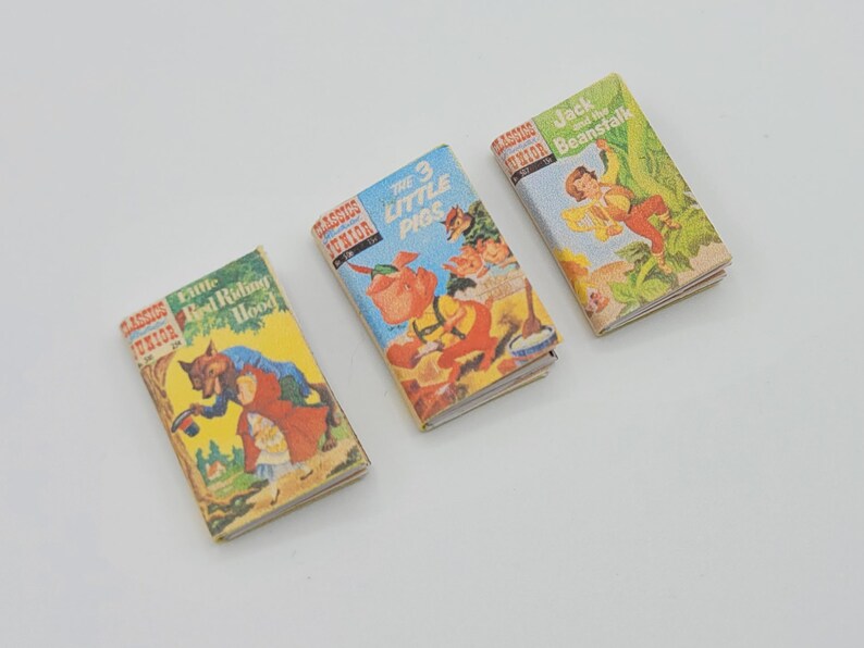 May include: Three miniature hardcover books with colorful illustrations. The titles are "Little Red Riding Hood", "The 3 Little Pigs", and "Jack and the Beanstalk".