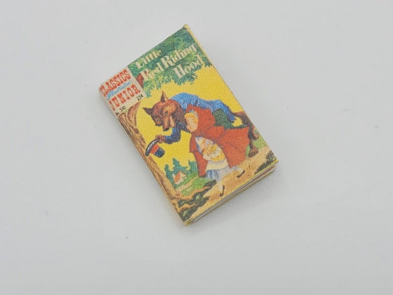 May include: A vintage Little Classics Junior book titled "Little Red Riding Hood" with a yellow cover and an illustration of a wolf and a girl in a red hood.