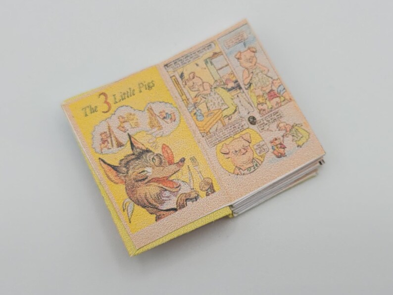 May include: A yellow and white children's book titled "The 3 Little Pigs" with illustrations of a wolf and pigs. The book is open to a page showing the wolf with a toothbrush.