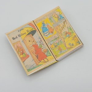 May include: An open book with the title "Little Red Riding Hood" on the cover. The book is illustrated with colorful cartoon images.
