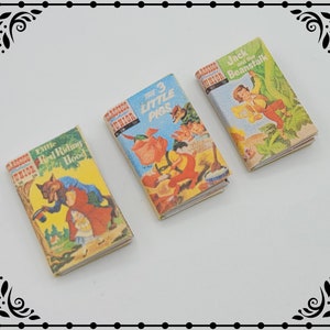 May include: Three miniature hardcover books with colorful illustrations. The titles are "Little Red Riding Hood", "The 3 Little Pigs", and "Jack and the Beanstalk".