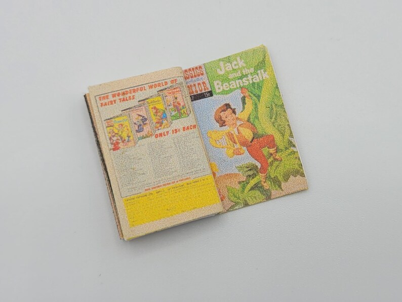 May include: An open book with a colorful cover featuring a boy climbing a beanstalk. The book's title is "Jack and the Beanstalk". The back cover features a colorful advertisement for "The Wonderful World of Fairy Tales".