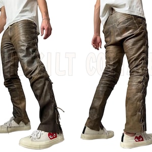 May include: Brown leather pants with lace-up detailing on the sides. The pants have a distressed look and a slight flare at the bottom. The pants are worn with white sneakers.