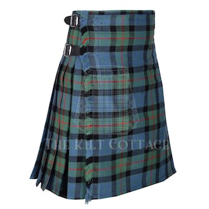 Peut inclure: Un kilt à carreaux bleu, vert et noir avec des touches de rouge. Il est orné de deux sangles en cuir noir avec boucles et d'une bordure effilochée. Le texte "THE KILT COTTAGE" est visible.