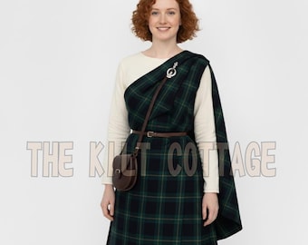 May include: A woman wearing a green and navy plaid kilt and shawl, secured with a silver brooch. A brown leather belt and small bag complete the outfit. The text "THE KILT COTTAGE" is visible in the image.