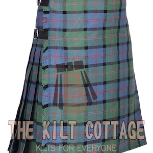 Könnte beinhalten: Ein blauer, grüner und schwarzer Tartan-Kilt mit einem Fransenrand und zwei Lederriemen. Der Kilt ist aus einem gewebten Stoff gefertigt und hat ein traditionelles schottisches Design. Der Text "THE KILT COTTAGE KILTS FOR EVERYONE" ist auf der Unterseite des Kilts aufgedruckt.