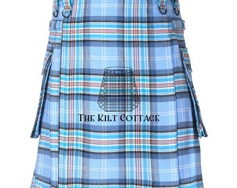May include: A light blue kilt with a classic plaid pattern in shades of blue, black, and red. The kilt features pleats, belt loops, and decorative buckles. The text "THE KILT COTTAGE" is printed on the front.
