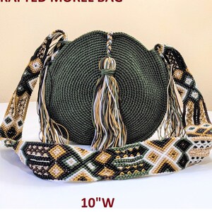 May include: Handcrafted green crochet bag with a geometric patterned strap and tassels. The bag measures 10 inches in height and 10 inches in width.