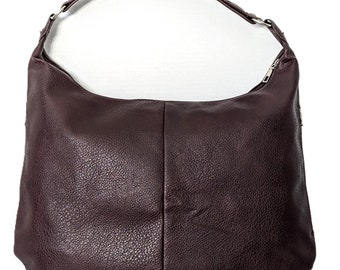 May include: Burgundy vegan leather shoulder tote handbag with a quilted pattern and five pockets. The bag is shown on a pink surface.