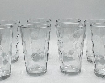 May include: Set of eight clear glass drinking glasses with a textured, bubble-like design.