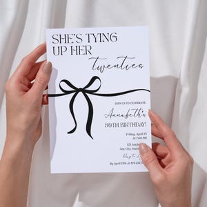 Puede incluir: Una tarjeta de invitaci&oacute;n blanca con texto negro y un dise&ntilde;o de lazo negro. El texto dice "She's Tying Up Her Twenties" e invita a los invitados a la celebraci&oacute;n del 30 cumplea&ntilde;os de Annabeth el 25 de abril a las 19:00.