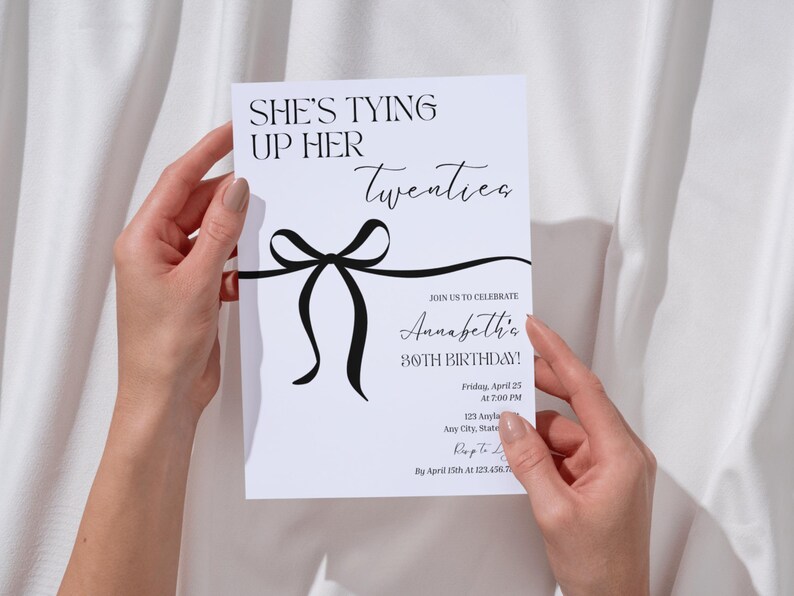 Puede incluir: Una tarjeta de invitaci&oacute;n blanca con texto negro y un dise&ntilde;o de lazo negro. El texto dice "She's Tying Up Her Twenties" e invita a los invitados a la celebraci&oacute;n del 30 cumplea&ntilde;os de Annabeth el 25 de abril a las 19:00.