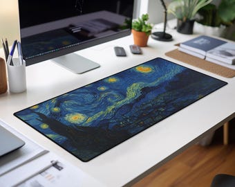 May include: A rectangular desk mousepad featuring a print of Van Gogh's "Starry Night" painting. The mousepad has a black border and is placed on a white desk, alongside a computer monitor and office supplies.