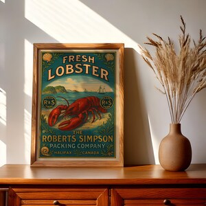 May include: A framed vintage-style print featuring a red lobster illustration. The teal background has the words "FRESH LOBSTER" and "THE ROBERTS SIMPSON PACKING COMPANY HALIFAX CANADA". The print is in a wooden frame, displayed on a wooden cabinet.