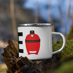 May include: White enamel mug with a black and white striped design and a red illustration of a small, round grill with a black lid and a thermometer on top.