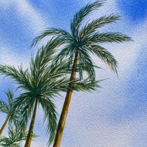 May include: Watercolour painting of three palm trees against a blue sky with white clouds. The trees are painted in shades of green and brown, with the leaves blowing in the wind.