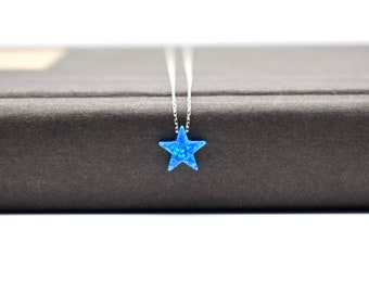 May include: A silver chain necklace with a blue star-shaped pendant.