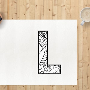 May include: A black and white illustration of the letter L with a decorative pattern of leaves, swirls, and dots.