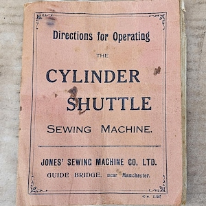May include: A vintage, rectangular instruction booklet with a faded pink cover and black text that reads: Directions for Operating THE CYLINDER SHUTTLE SEWING MACHINE. JONES' SEWING MACHINE CO. LTD. GUIDE BRIDGE, near Manchester. 40 M. 11/26.