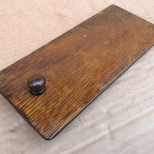 Pu&ograve; includere: Una maniglia per cassetto in legno con finitura marrone scuro e un pomo rotondo. La maniglia &egrave; in legno massello e presenta una venatura naturale.