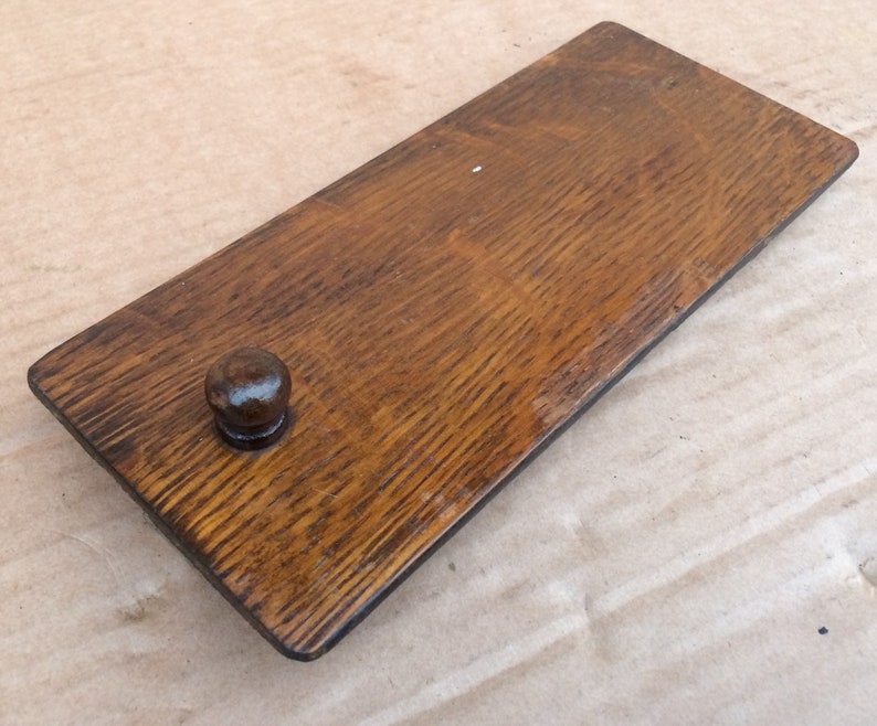 Pu&ograve; includere: Una maniglia per cassetto in legno con finitura marrone scuro e un pomo rotondo. La maniglia &egrave; in legno massello e presenta una venatura naturale.