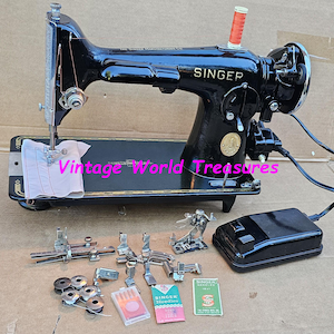 May include: A vintage black Singer sewing machine with accessories. The machine features the Singer logo and an orange thread spool. Includes presser feet, bobbins, and needle packs. The text "Vintage World Treasures" is visible.