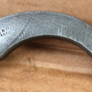 Op de afbeelding: Een zilveren metalen fietsdeel met een schroef en de tekst "COIREO SIMANCO" erop.