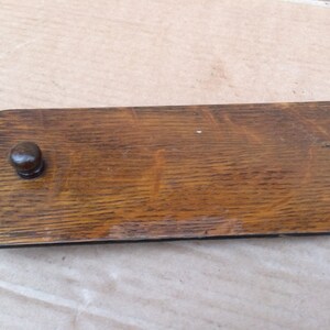 Pu&ograve; includere: Una maniglia per cassetto in legno con finitura marrone scuro e un pomello rotondo. La maniglia ha un design semplice ed &egrave; realizzata in legno massello.