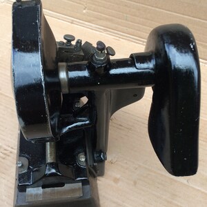 Puede incluir: M&aacute;quina de metal negro con una cabeza redonda grande y una cabeza m&aacute;s peque&ntilde;a con un mango. La m&aacute;quina tiene varios botones y una placa de metal en la parte inferior.